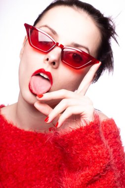 Kırmızı güneş gözlüklü genç kadın, kırmızı ruj, kırmızı kazak.