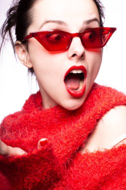 Kırmızı güneş gözlüklü genç kadın, kırmızı ruj, kırmızı kazak.