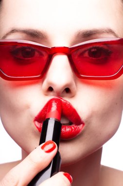 Kırmızı güneş gözlüklü genç kadın, kırmızı ruj, kırmızı kazak.