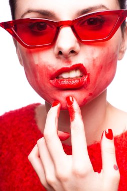 Kırmızı güneş gözlüklü genç kadın, kırmızı ruj, kırmızı kazak.