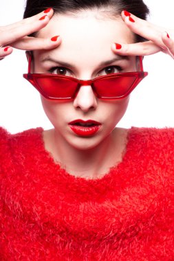 Kırmızı güneş gözlüklü genç kadın, kırmızı ruj, kırmızı kazak.