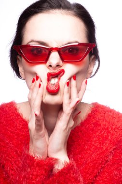 Kırmızı güneş gözlüklü genç kadın, kırmızı ruj, kırmızı kazak.