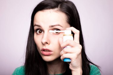 Güzel kız öksürük şurubu tutuyor.