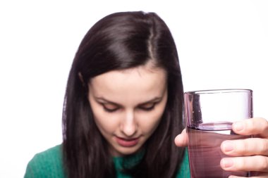 Güzel kız bir bardak su tutuyor.