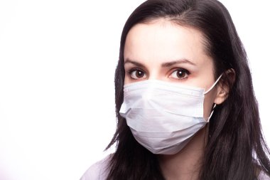 Yüzünde tıbbi maske olan genç bir kadın.