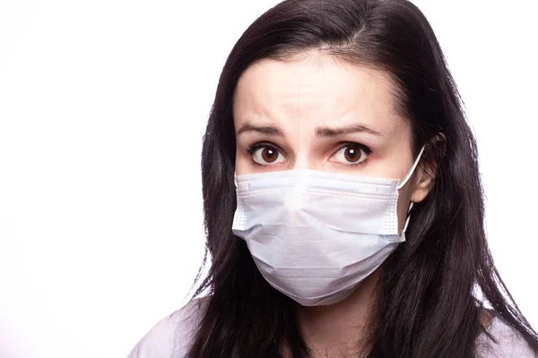 Yüzünde tıbbi maske olan genç bir kadın.