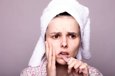 Güzel genç bir kadın dişlerini fırçalıyor, acı çekiyor.