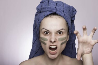 Kafasında havlu ve yüzünde maske olan genç bir kadın.