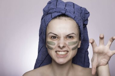 Kafasında havlu ve yüzünde maske olan genç bir kadın.