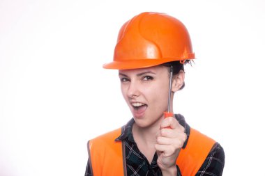 Kasklı güzel bir genç kız işçi elinde bir tornavida tutuyor.