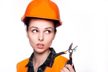 Kasklı güzel genç kız işçi elinde pense tutuyor.