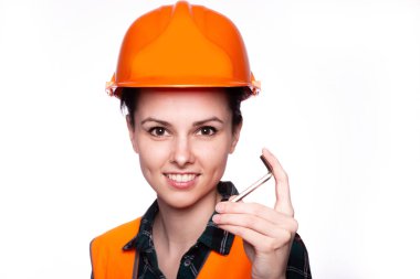Turuncu kasklı, elinde Allen anahtarlarıyla güzel bir genç kız işçi.
