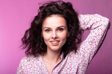 Pijamalı güzel kıvırcık kız pembe arka plan