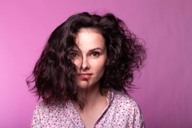 Pijamalı güzel kıvırcık kız pembe arka plan