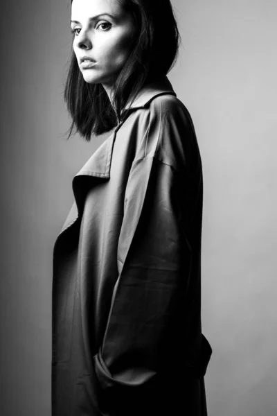 beautiful young girl in a trench coat, black and white