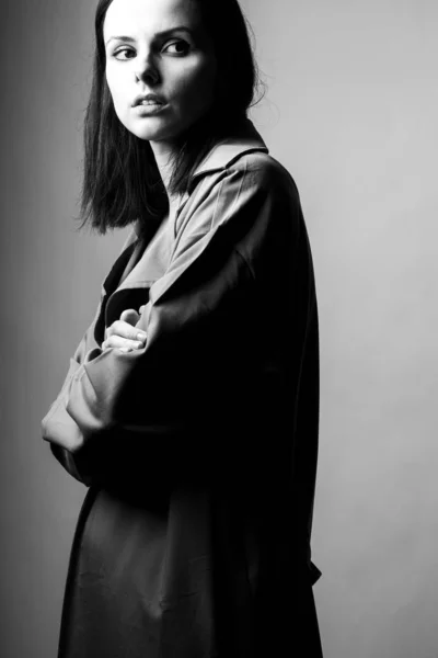 beautiful young girl in a trench coat, black and white