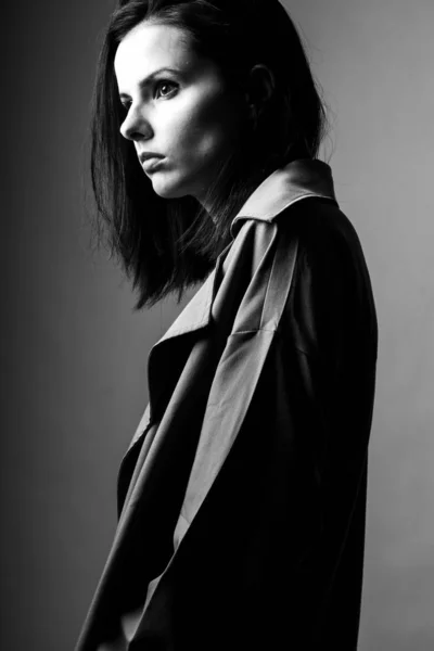 beautiful young girl in a trench coat, black and white