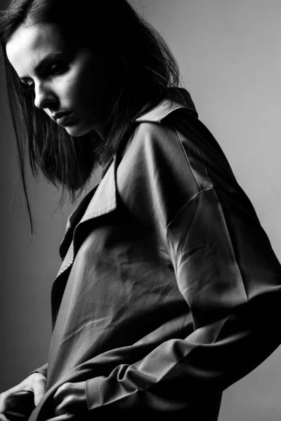 beautiful young girl in a trench coat, black and white