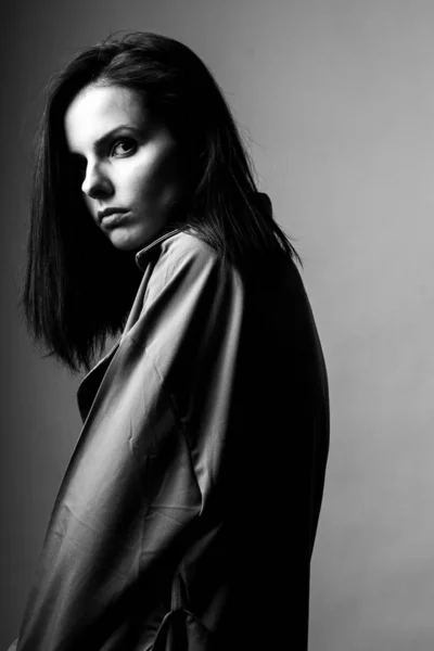 beautiful young girl in a trench coat, black and white