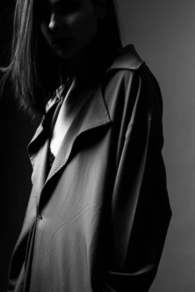 beautiful young girl in a trench coat, black and white