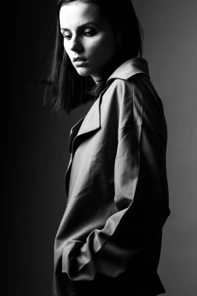 beautiful young girl in a trench coat, black and white