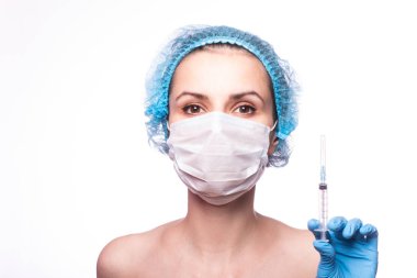 Gözlüklü ve eldivenli genç bir kız elinde bir şırınga tutuyor.