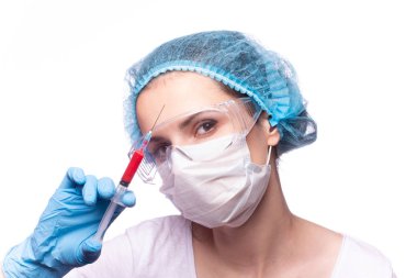 Gözlüklü ve eldivenli genç bir kız elinde bir şırınga tutuyor.