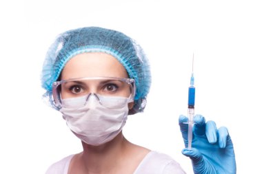 Tıp maskeli, gözlüklü ve eldivenli genç bir kız elinde mavi sıvı bir şırınga tutuyor.