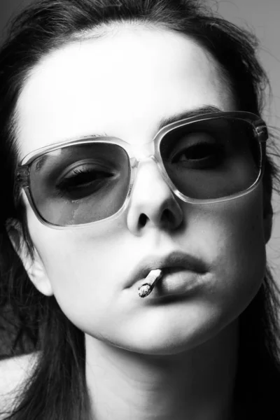 口の中にタバコを入れたサングラスの美しい少女黒と白の写真 — ストック写真
