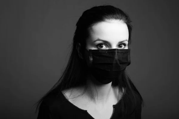 beautiful young girl in a black medical respirator black and white portrait