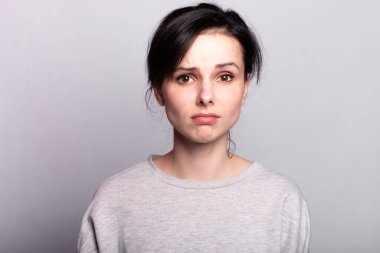 Gri arka planda güzel, anlamlı bir kadın, tek renk.
