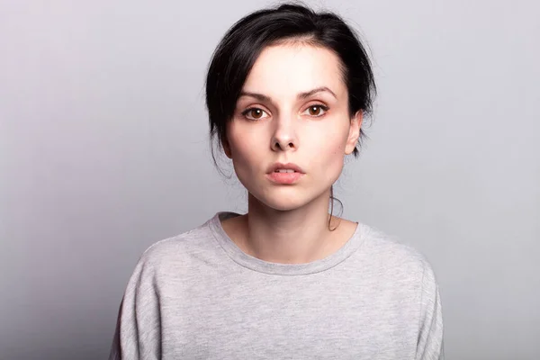 lovely girl in a gray t-shirt on a gray background