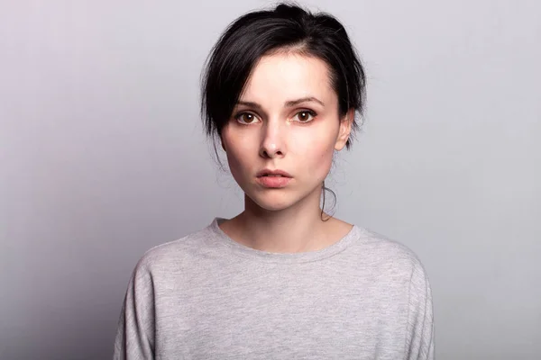 lovely girl in a gray t-shirt on a gray background