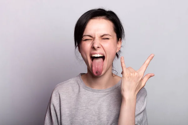 emotional  woman  in a gray t-shirt on a gray background