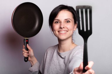 yemek hazırlayan duygusal kadın, bulaşıkların elinde, gri arka plan