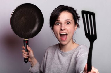 yemek hazırlayan duygusal kadın, bulaşıkların elinde, gri arka plan
