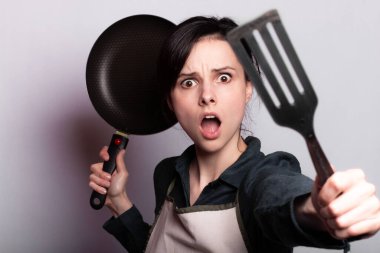 Kahvaltı hazırlayan anlamlı kadın, gri arka plan.