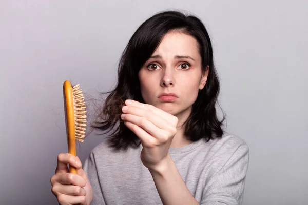 手に櫛を持つ女性問題髪 — ストック写真