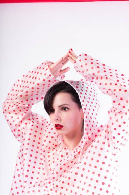 Yağmurluk giymiş kırmızı dudaklı güzel kız. 