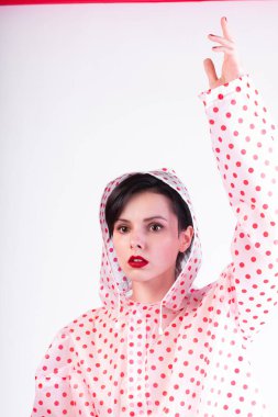 Yağmurluk giymiş kırmızı dudaklı güzel kız. 