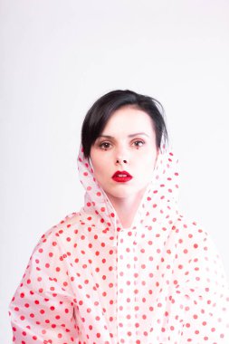 Yağmurluk giymiş kırmızı dudaklı güzel bir kadın. 