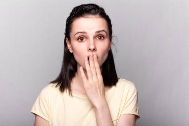 Sarı tişörtlü, gri arka planlı, duygusal portresi olan komik kadın.