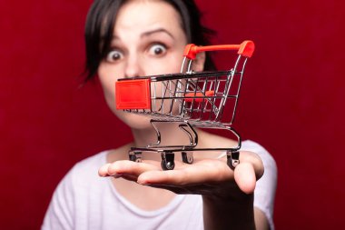 Kadın süpermarket arabası gösteriyor.