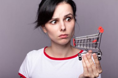 Bir kadın dükkandan küçük bir tramvay tutuyor.