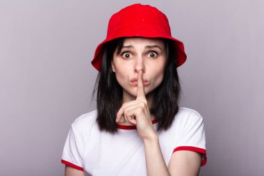 Kırmızı panama şapkalı bir kadın, elinde bir süpermarketten alınmış oyuncak bir tramvay tutuyor, finansal refahın sembolü.