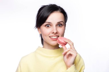 Sarı kazaklı güzel kadın elinde makarna kurabiyeleri tutuyor.