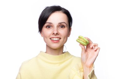 Sarı kazaklı güzel kadın elinde makarna kurabiyeleri tutuyor.