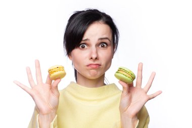 Sarı kazaklı güzel kadın elinde makarna kurabiyeleri tutuyor.