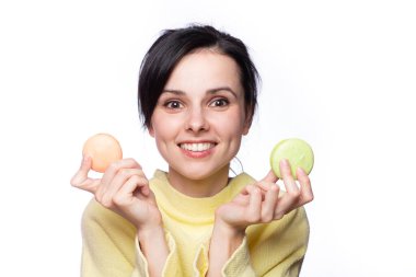 Sarı kazaklı tatlı kadın elinde makarna kurabiyeleri tutuyor. 