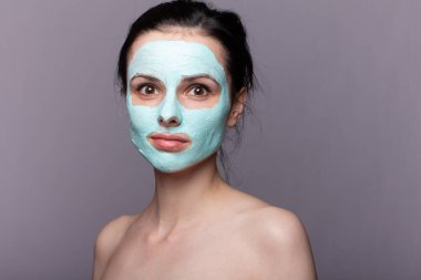 Kozmetik maskeli kadın, sorunlu cilt, gri arka plan